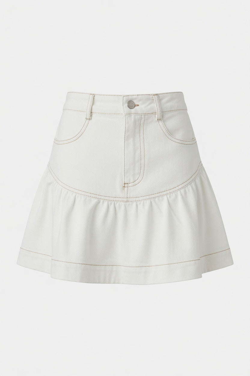 A close-up of a white denim mini skirt with a ruffled hem and contrast tan stitching