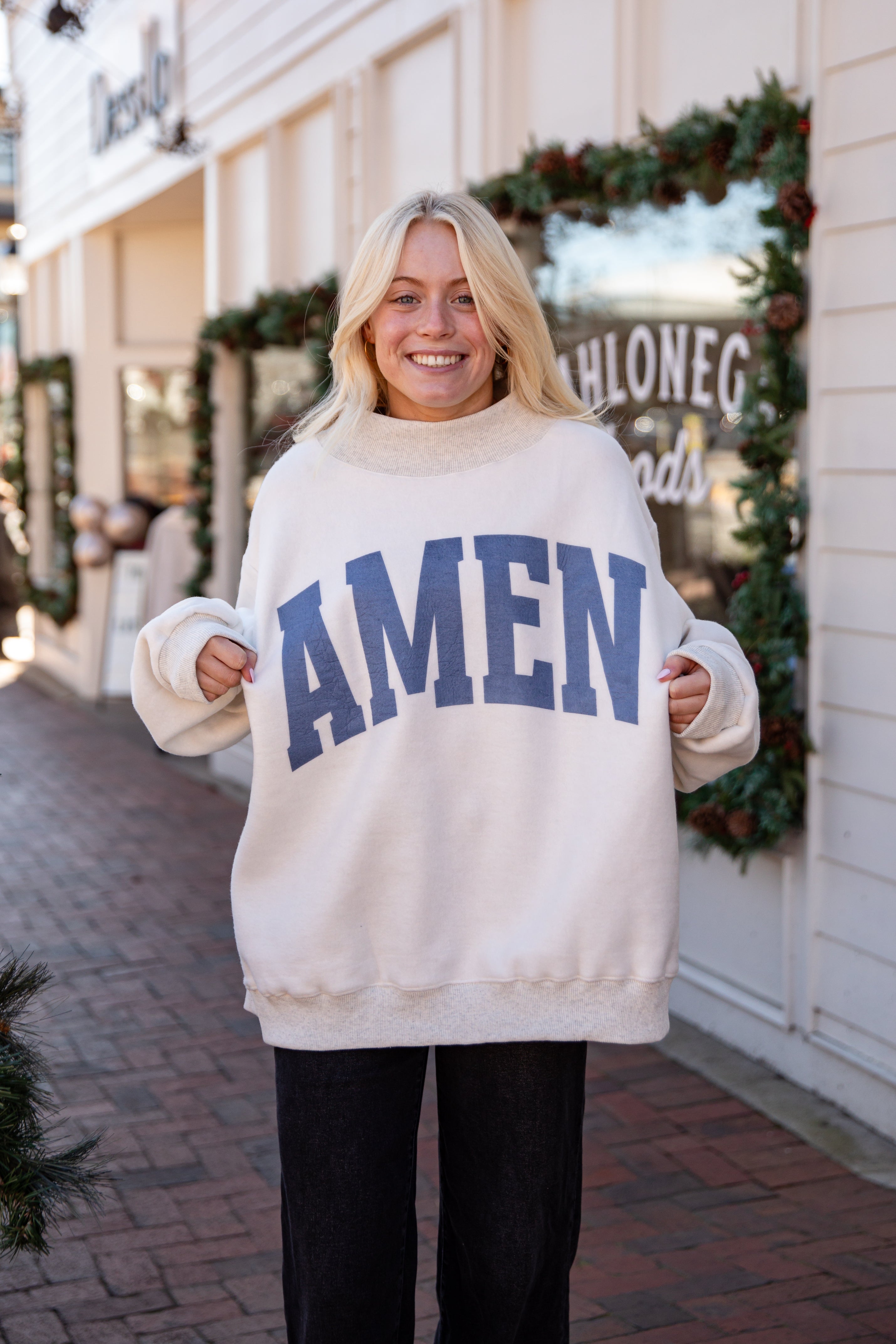 Person wearing a white sweater with &