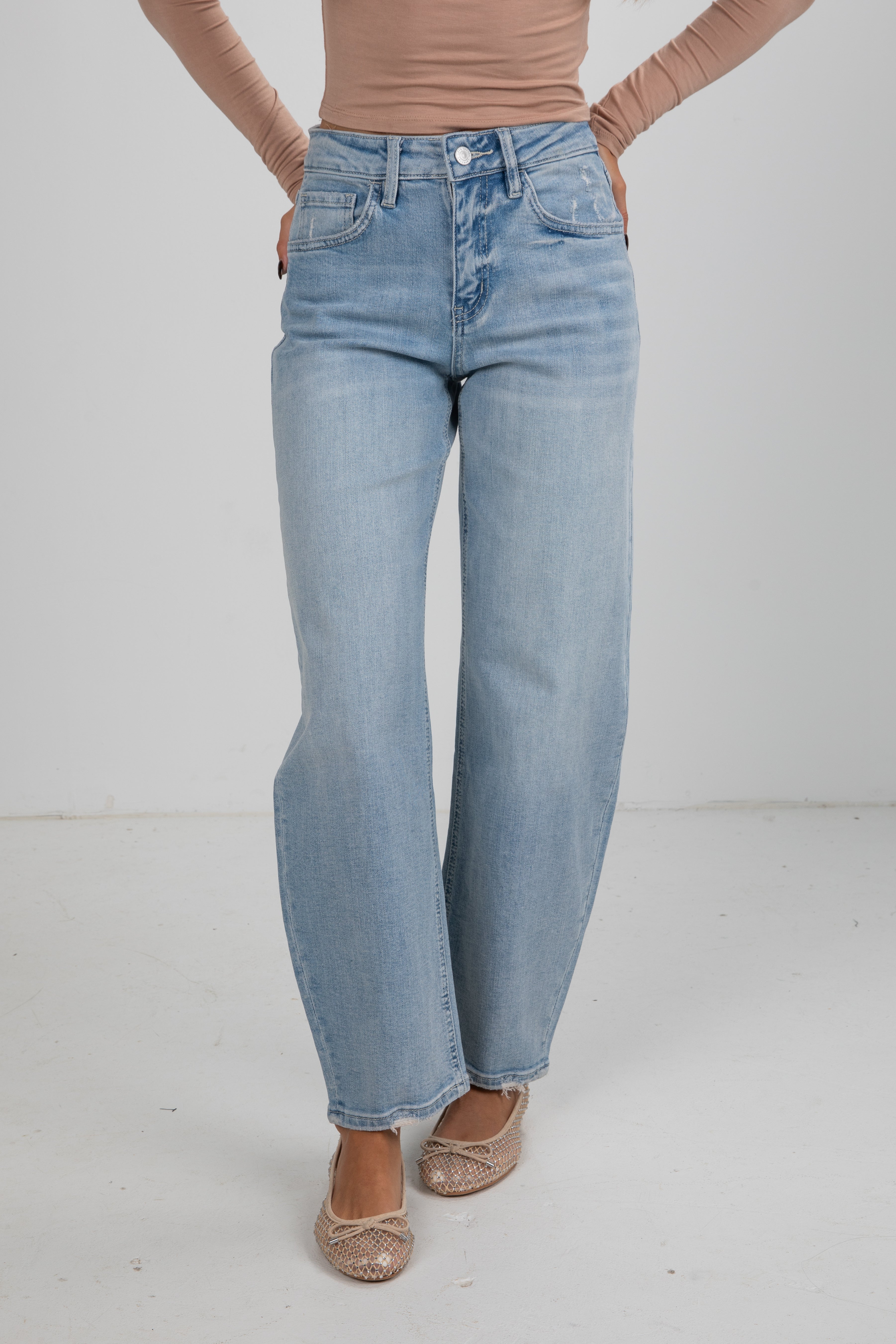 Person wearing light blue jeans on a white background