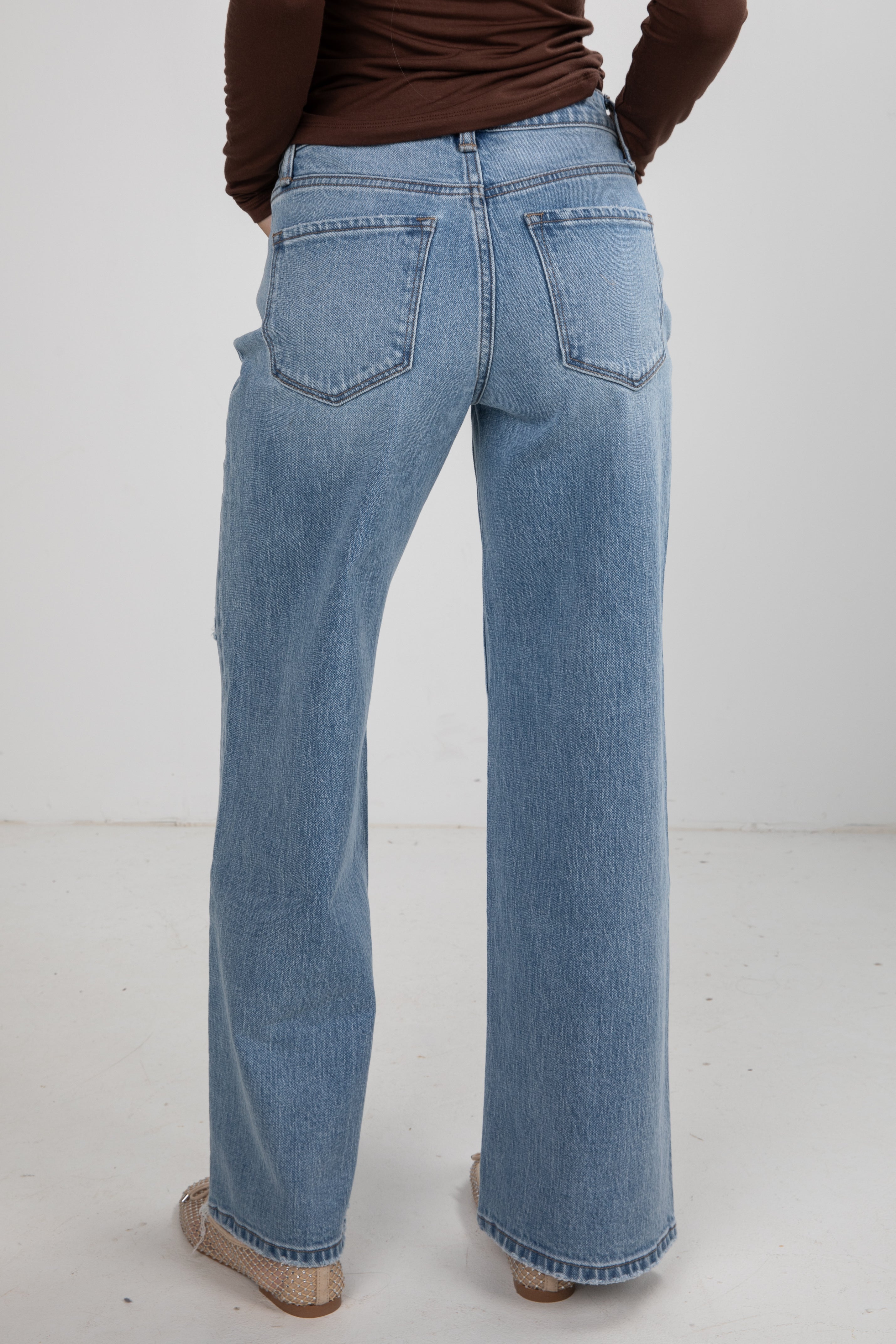 Person wearing blue jeans on a white background