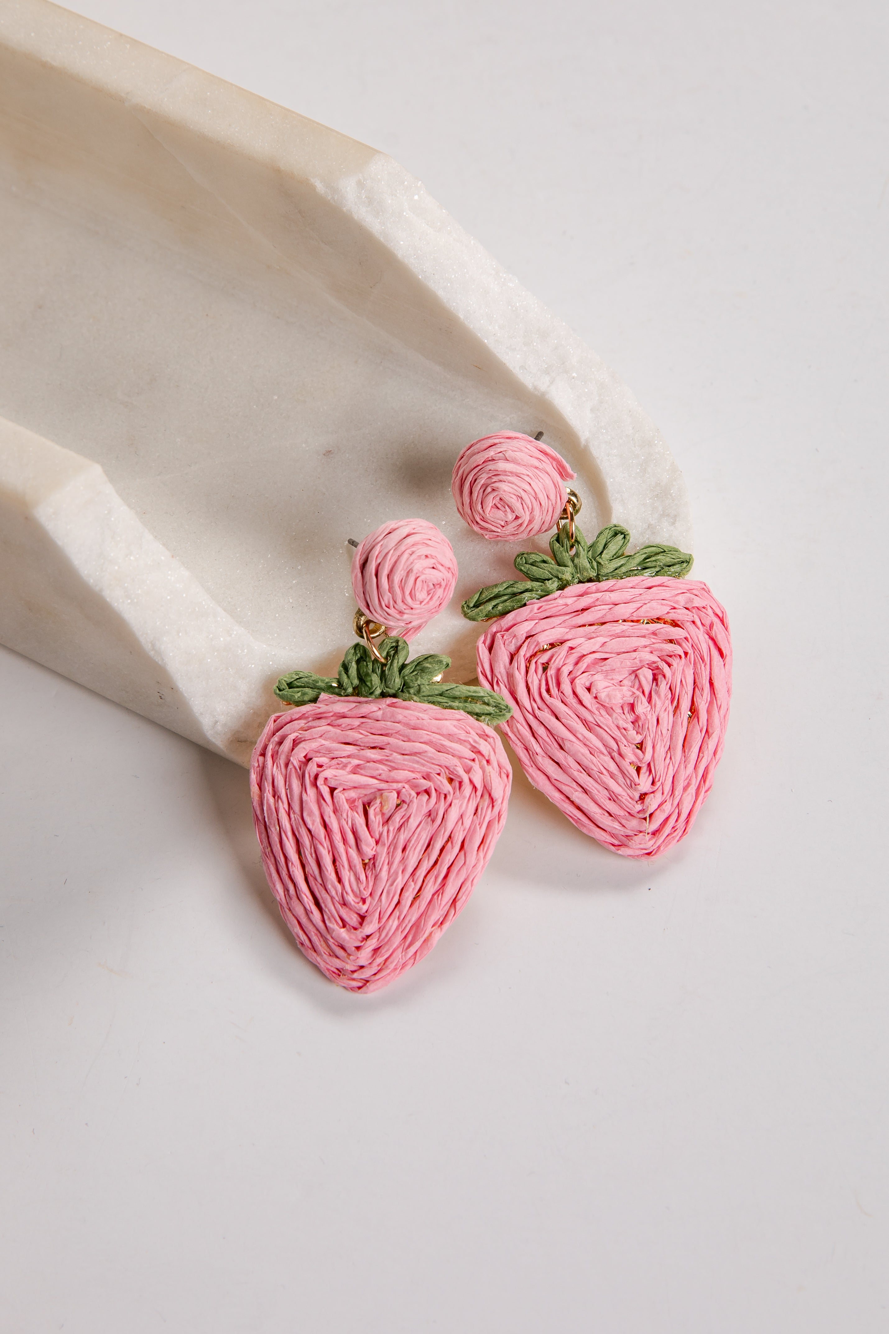 Pink strawberry-shaped earrings on a white background