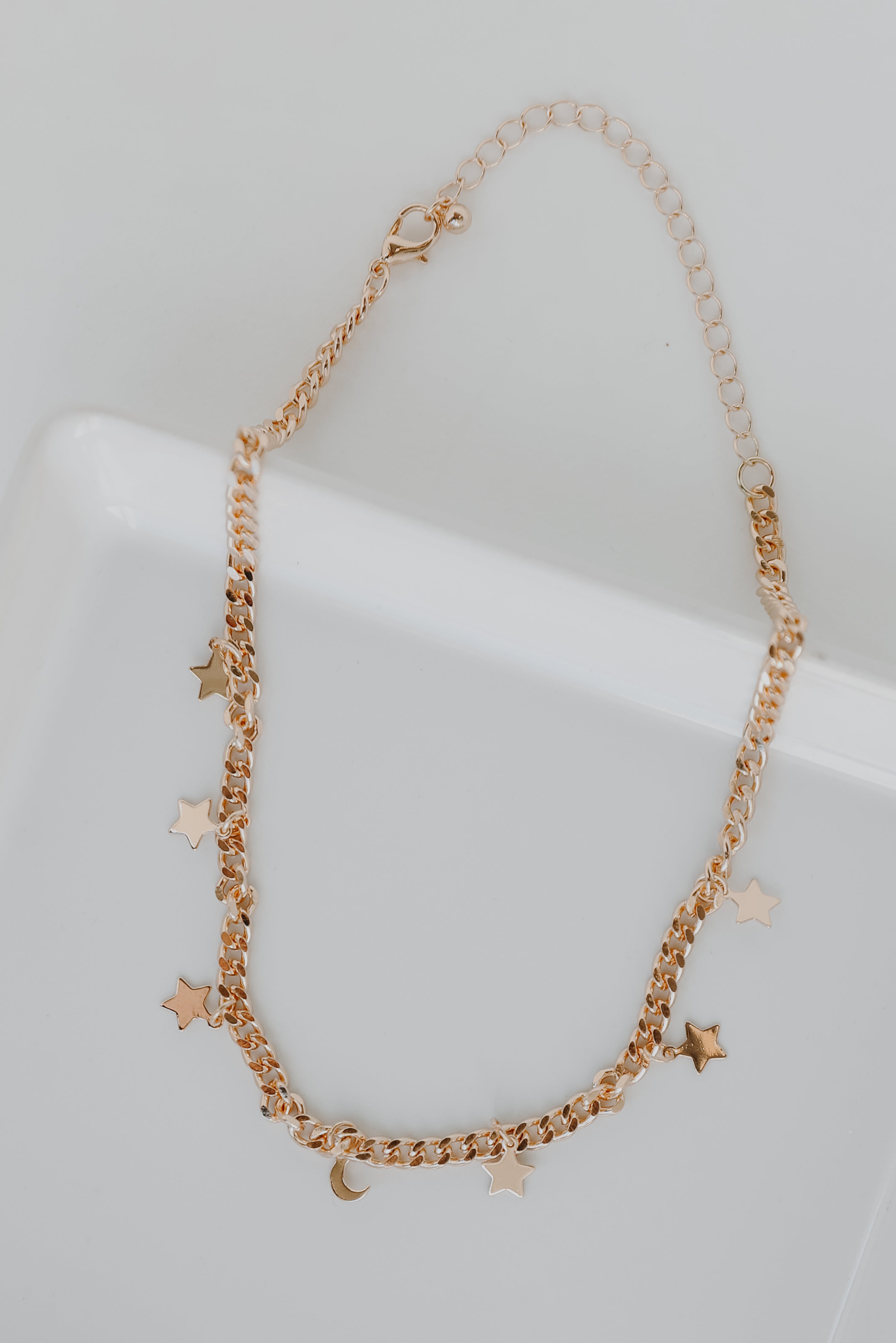 Gold Star + Moon Necklace flat lay