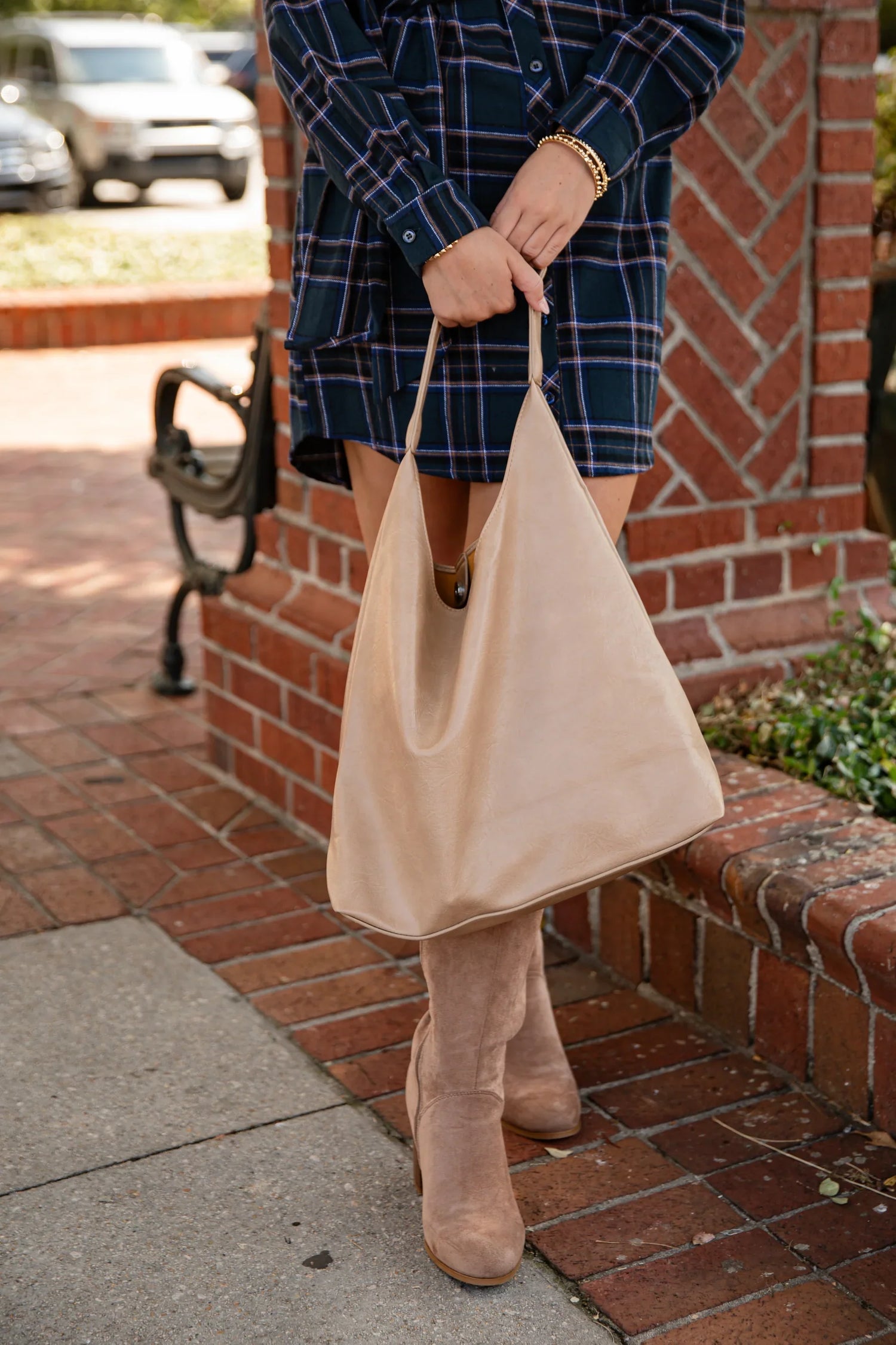 Woman holding a tan purse hand bag. Tan bag. Purse. Hand bags