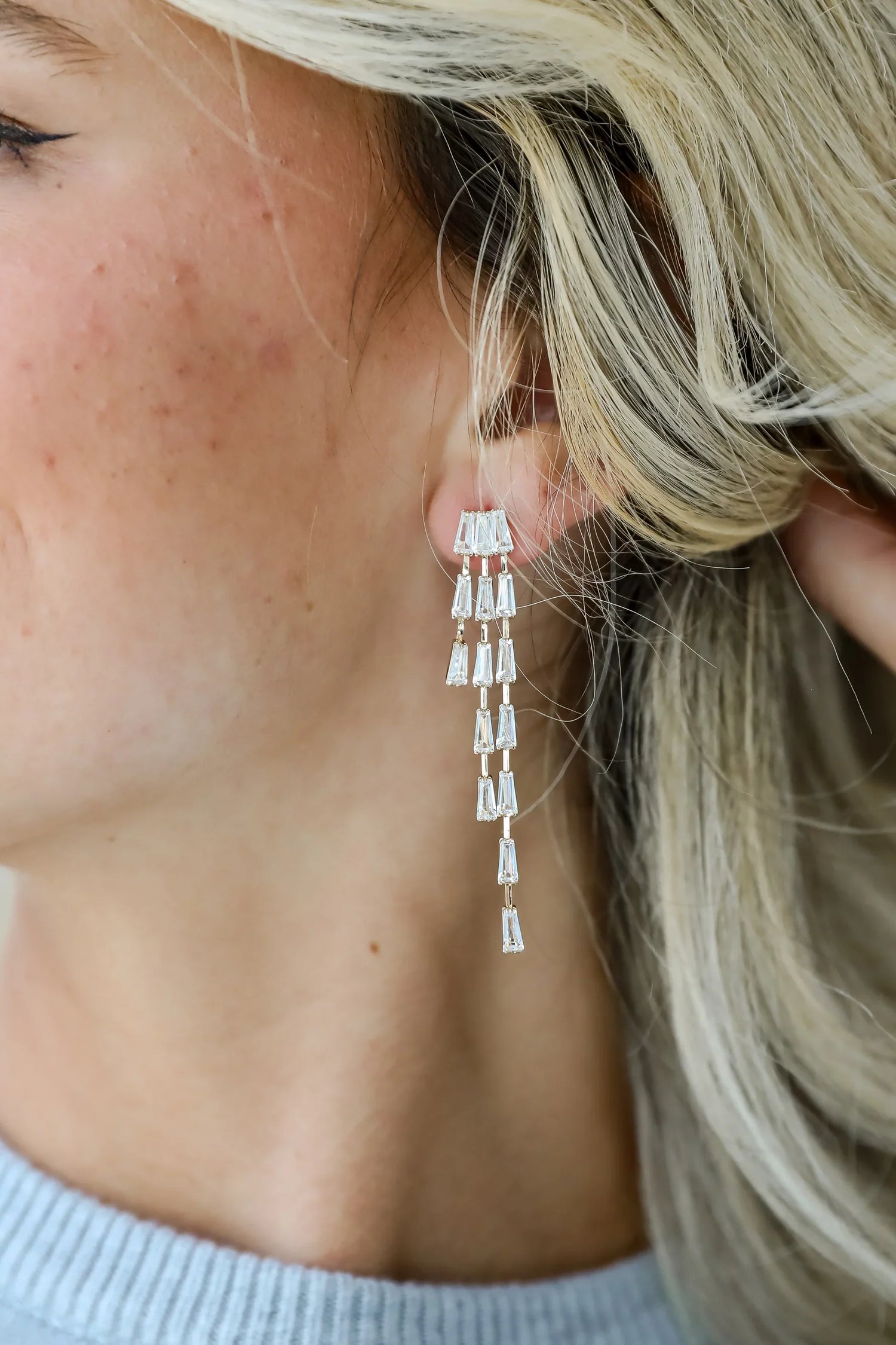woman wearing gold rhinestone earrings