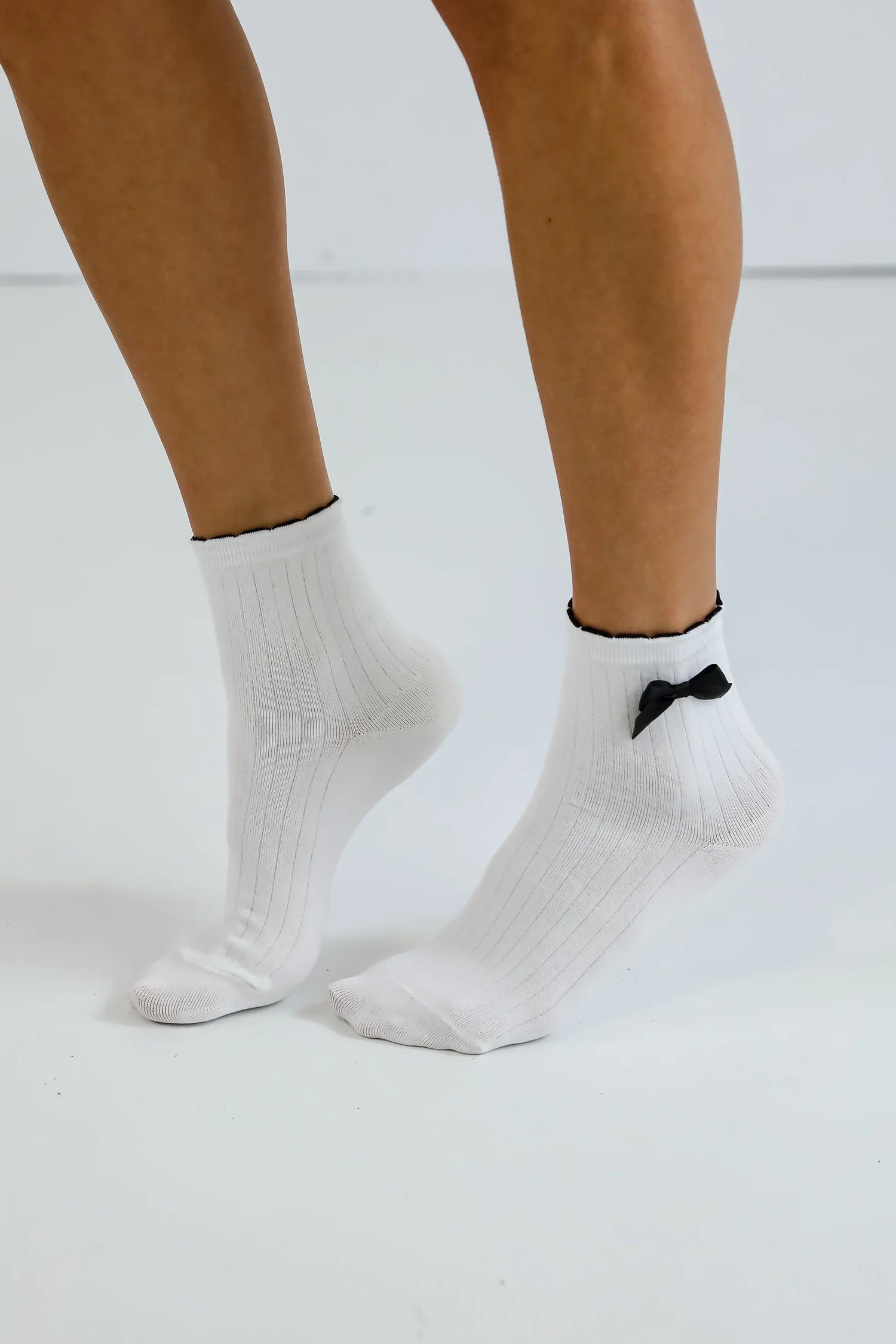 Woman wearing white ankle sock with a black bow
