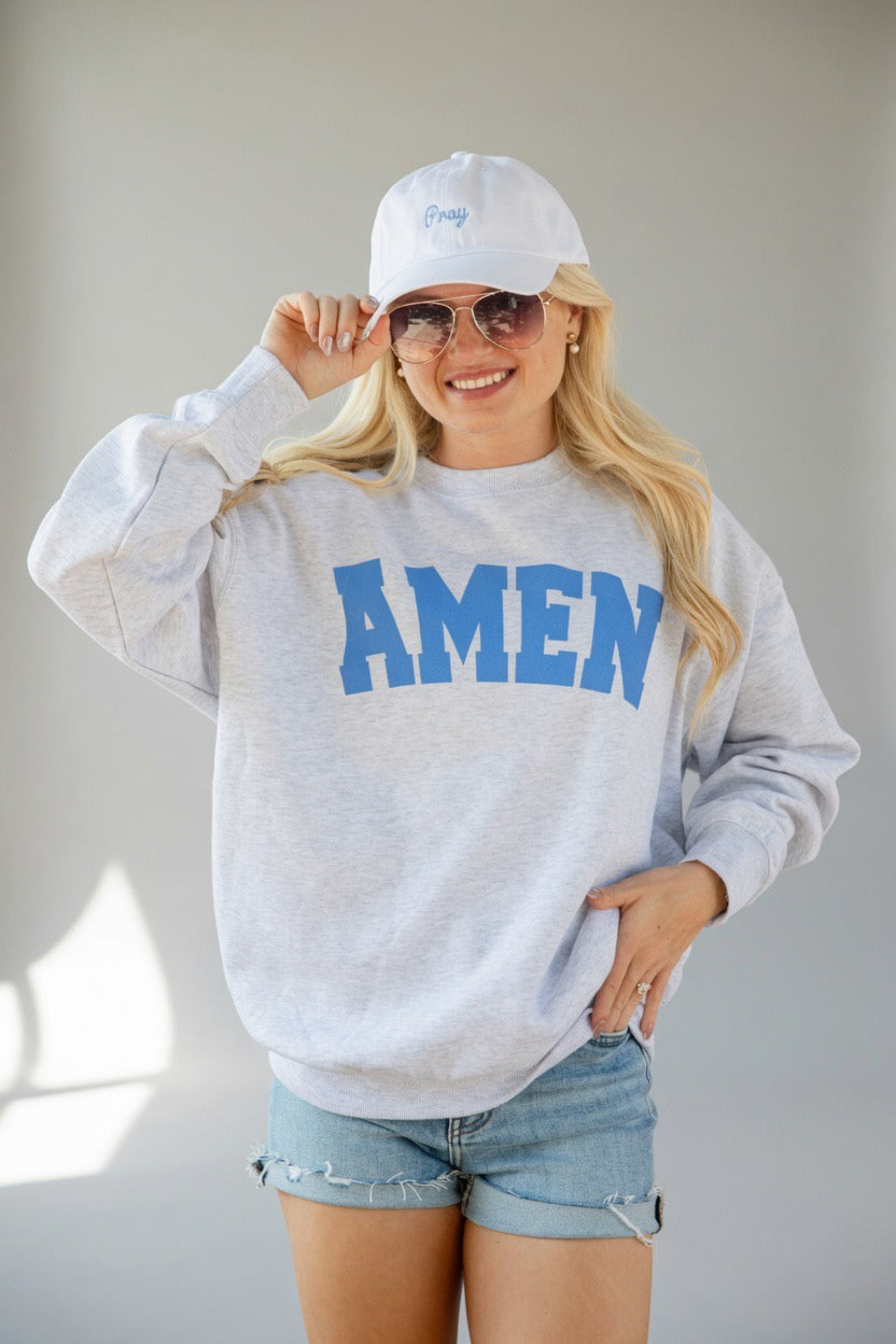 A woman wearing a light gray heather sweatshirt with &
