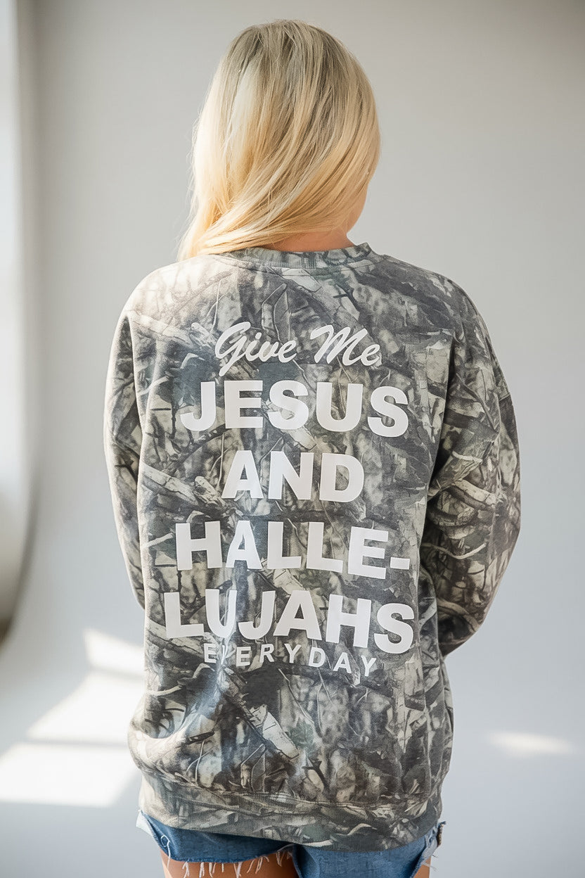 A woman viewed from behind wearing a gray and black camouflage sweatshirt with bold white text on the back that reads, &