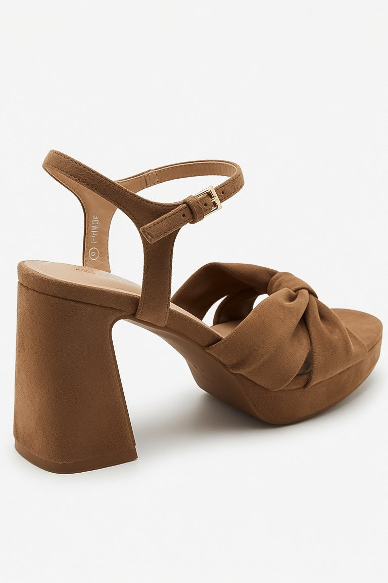 A single brown suede-like block-heel sandal with an ankle strap and knotted front detail, shown on a clean white background.