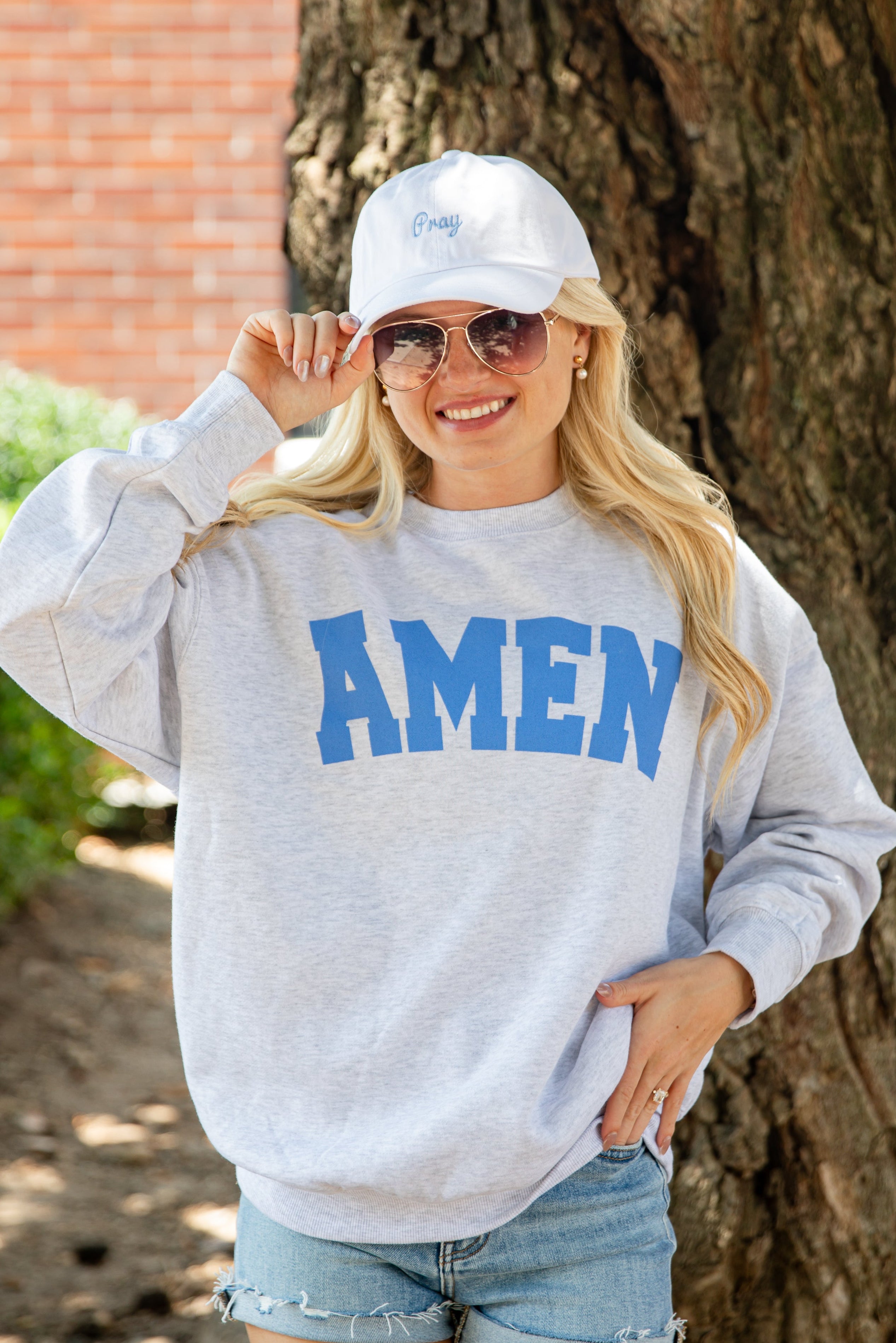 A woman wearing a light heather gray sweatshirt with &