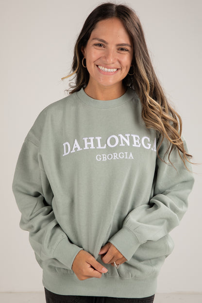 Woman wearing a green sweatshirt with &