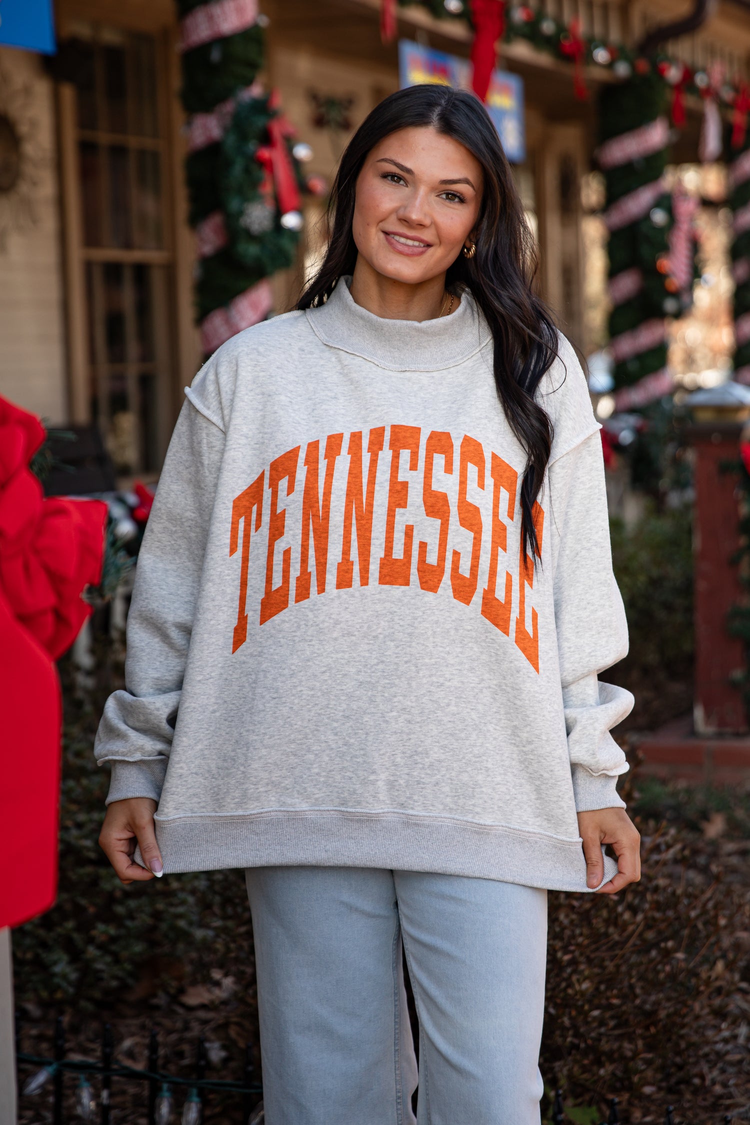 Person wearing a gray sweatshirt with &