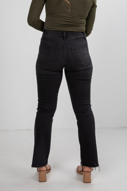 Person wearing black jeans and a green top on a white background