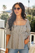 Woman wearing a striped blouse and sunglasses outdoors