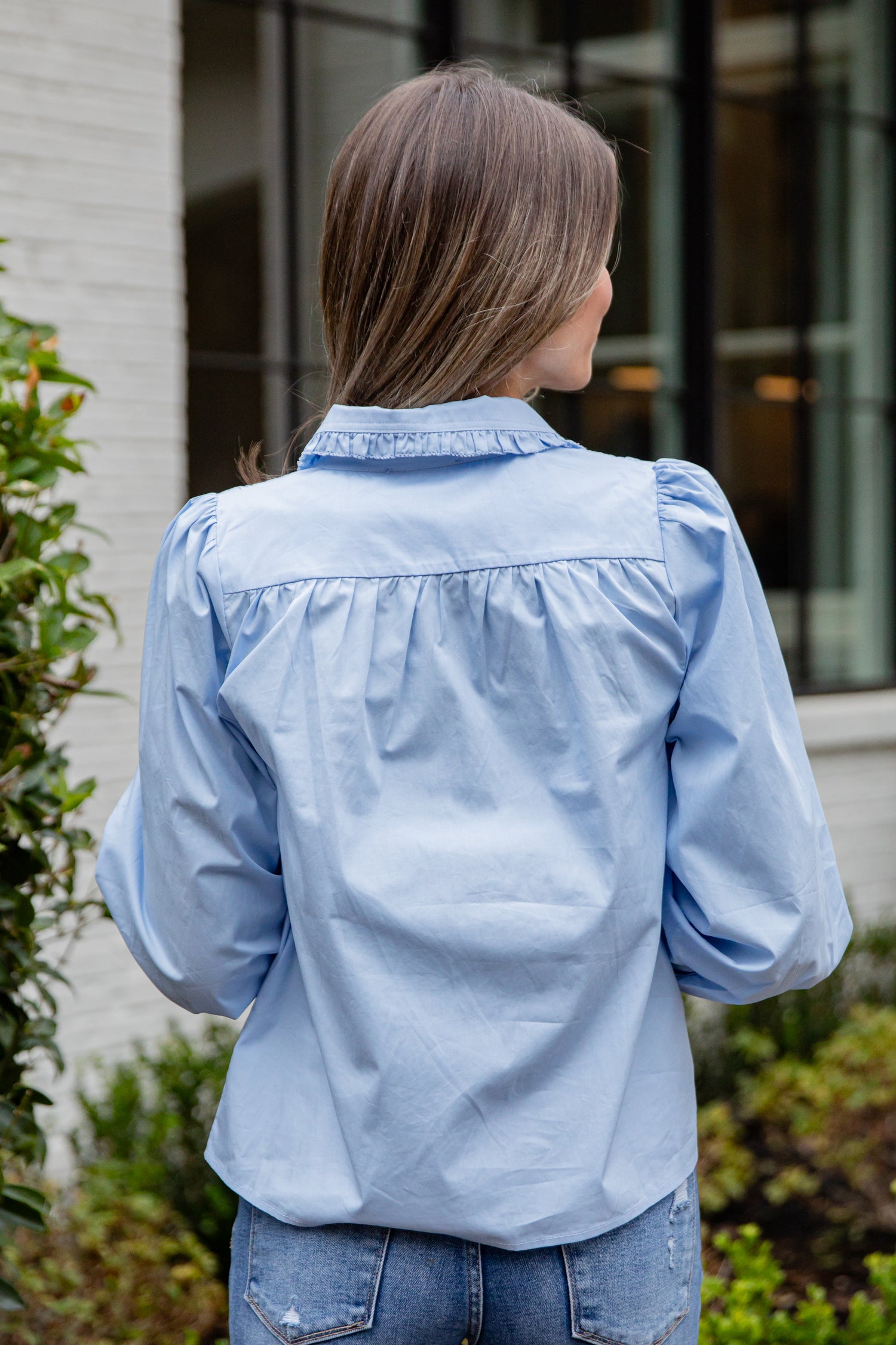 Woman wearing a light blue denim jacket outdoors