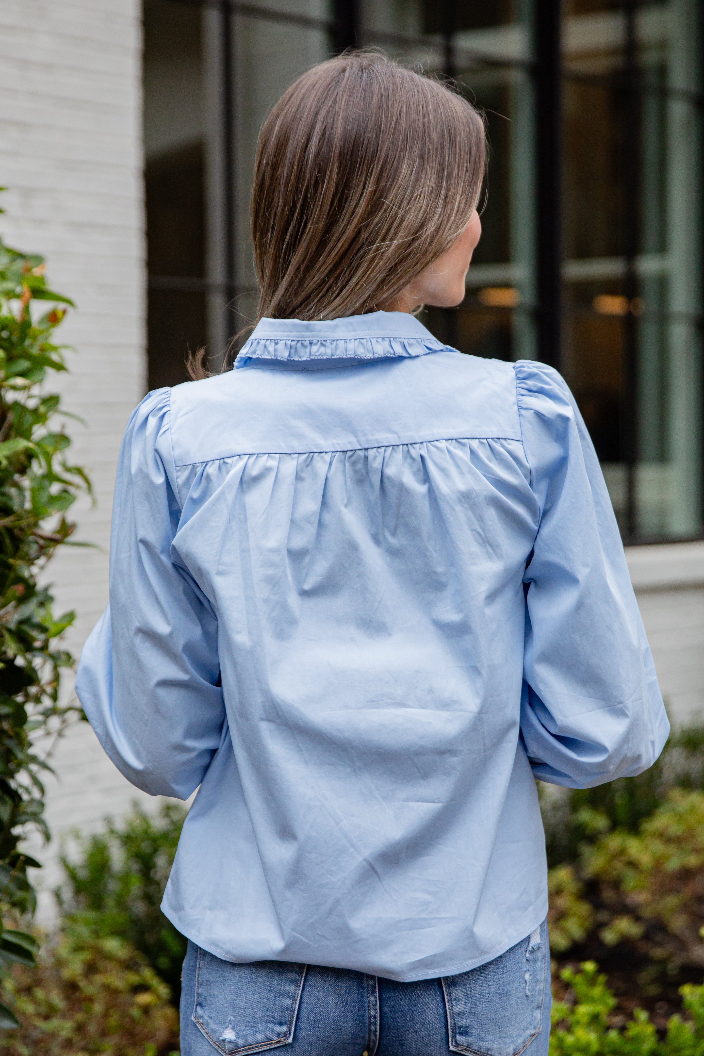 Woman wearing a light blue denim jacket outdoors