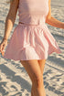 Person wearing a pink dress on a sandy beach