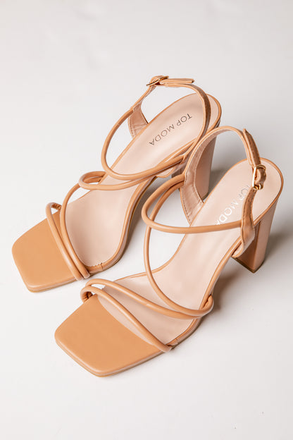 Pair of tan high-heeled sandals on a light gray background