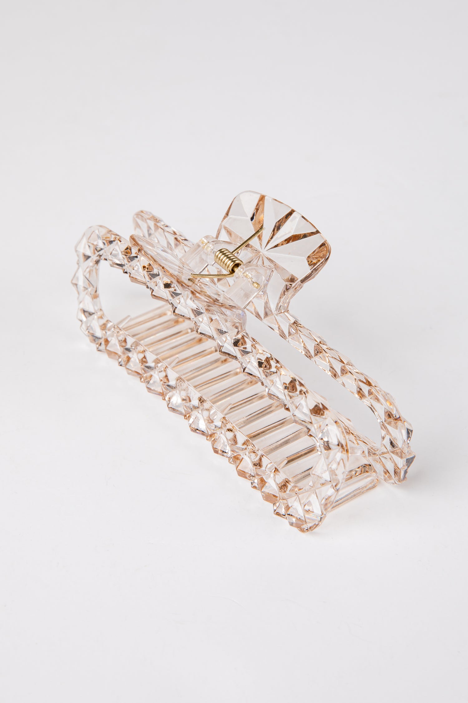 Clear hair clip with gold accents on a white background