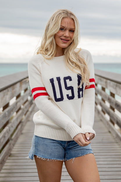 Woman wearing a white sweater with &
