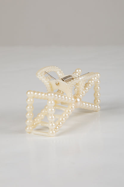 Pearl-clad clutch bag on a light gray background
