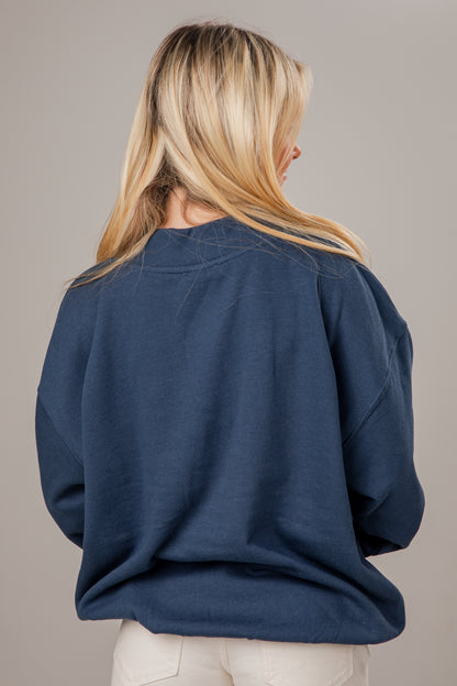 Person wearing a blue mock neck on a plain background
