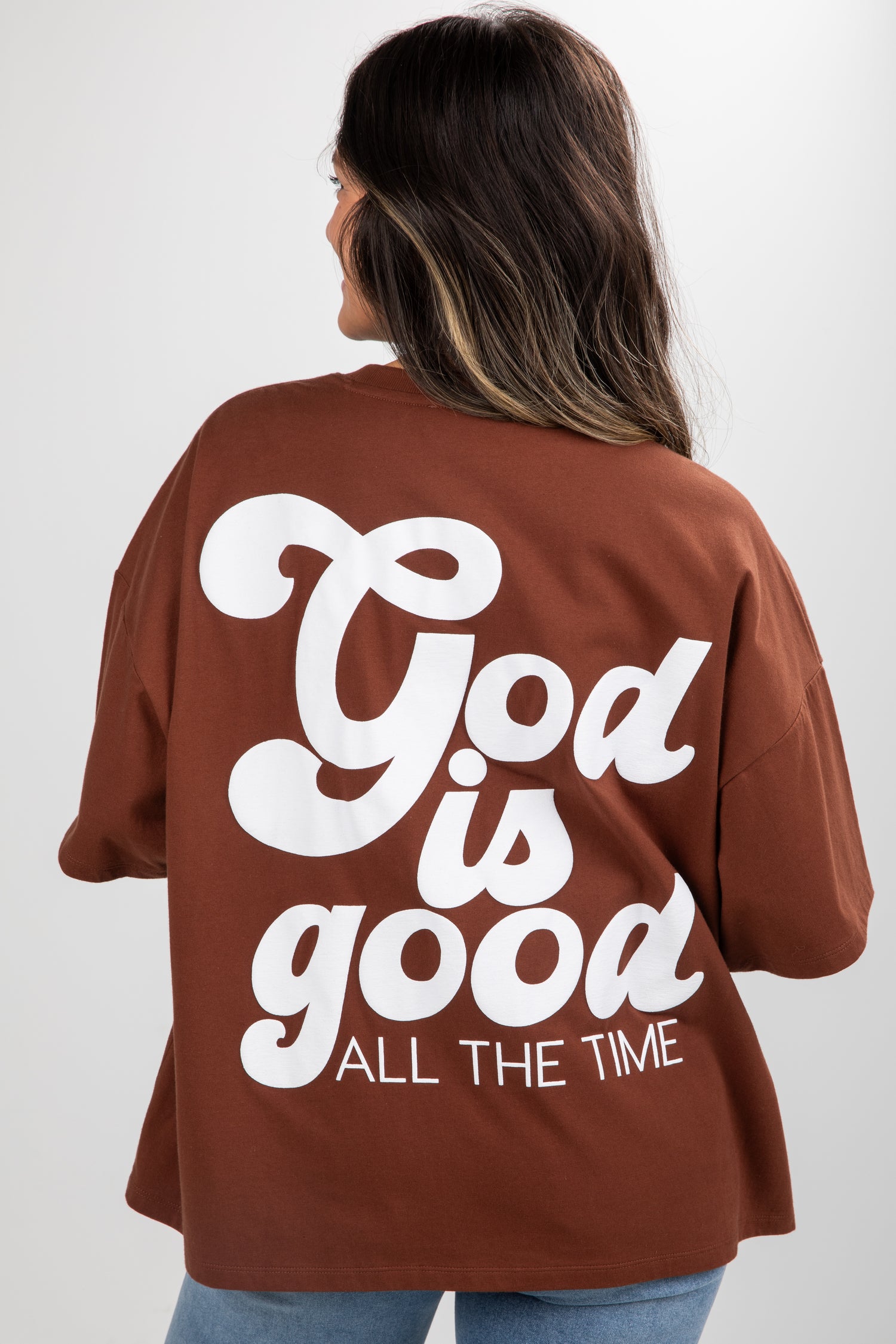 Person wearing a brown shirt with &