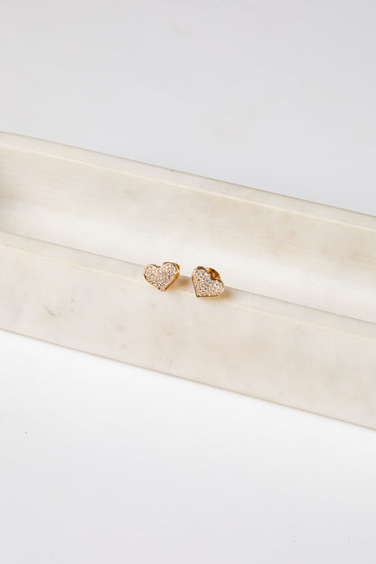 Gold heart-shaped earrings on a white satin ribbon