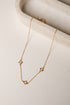 Gold necklace with star-shaped pendants on a marble surface