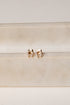 Rose gold elephant earrings on a beige background