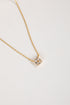 Gold necklace with a star-shaped pendant on a light gray background