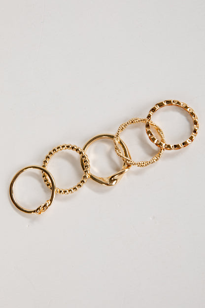 Gold ring with multiple interconnected rings on a light gray background