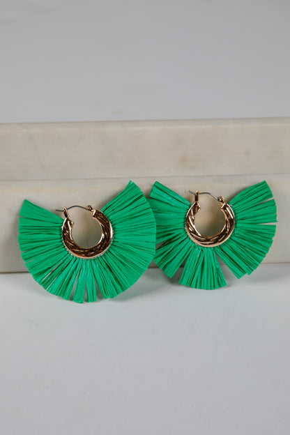 Green ruffled earrings with gold hoop centers on a light gray background