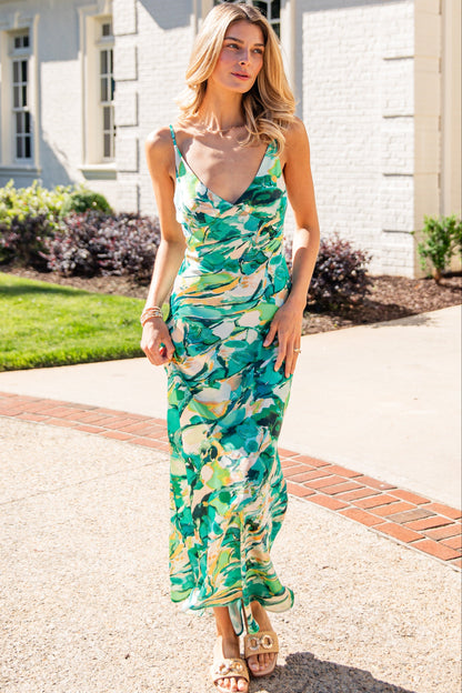 Woman in a floral dress standing on a driveway with a house in the background