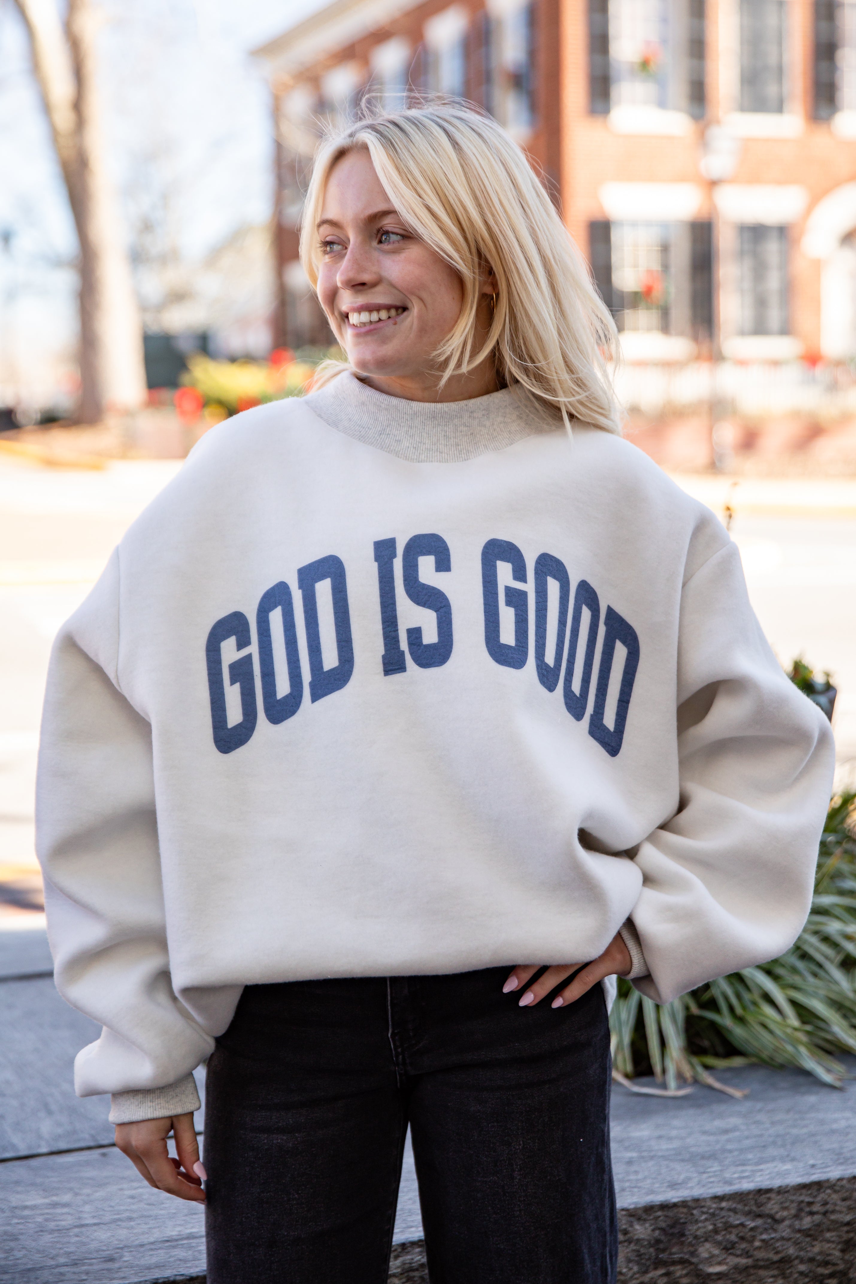 Person wearing a beige sweatshirt with &