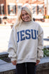 Person wearing a gray sweatshirt with &