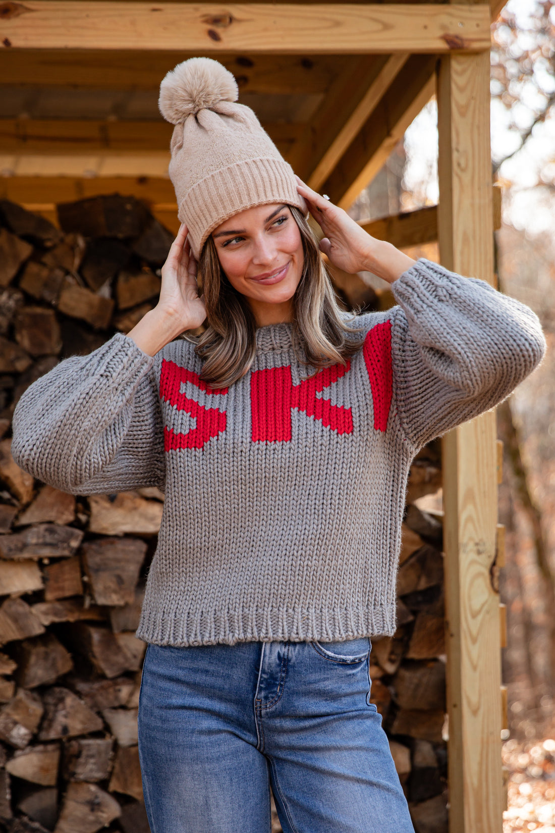 Woman wearing a gray sweater with &