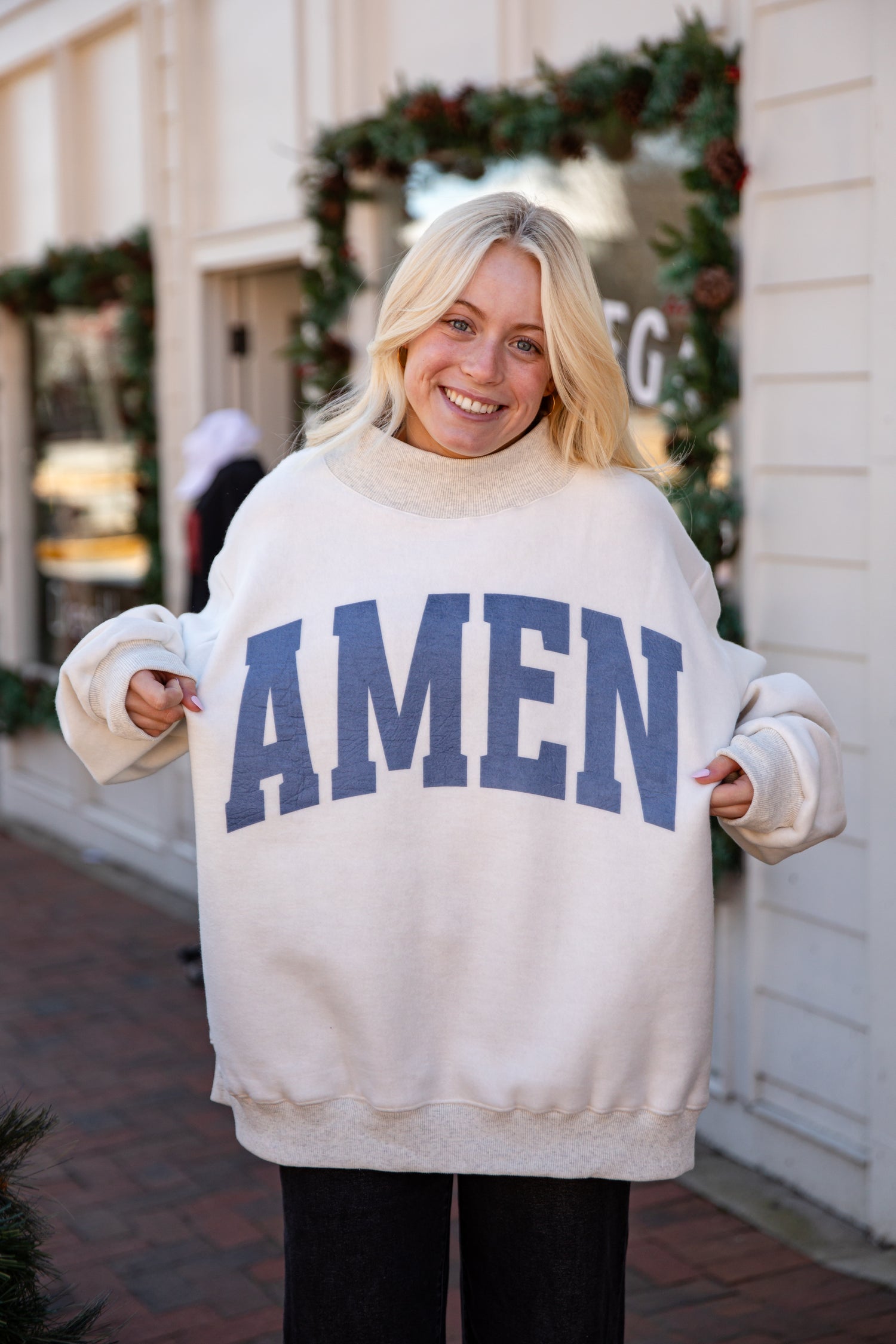 Person wearing a cream sweater with &