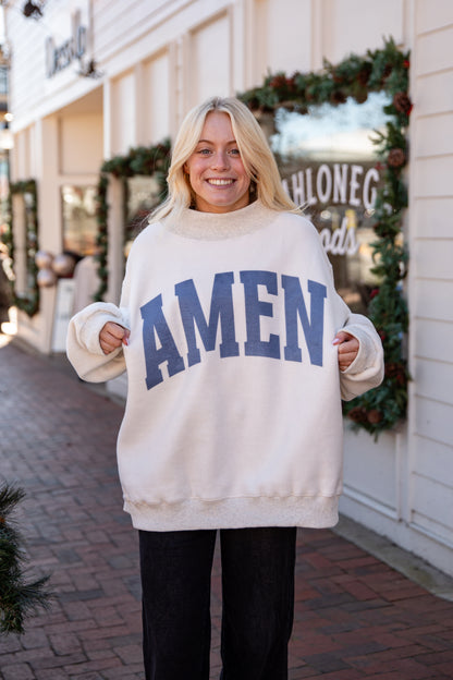 Person wearing a white sweater with &