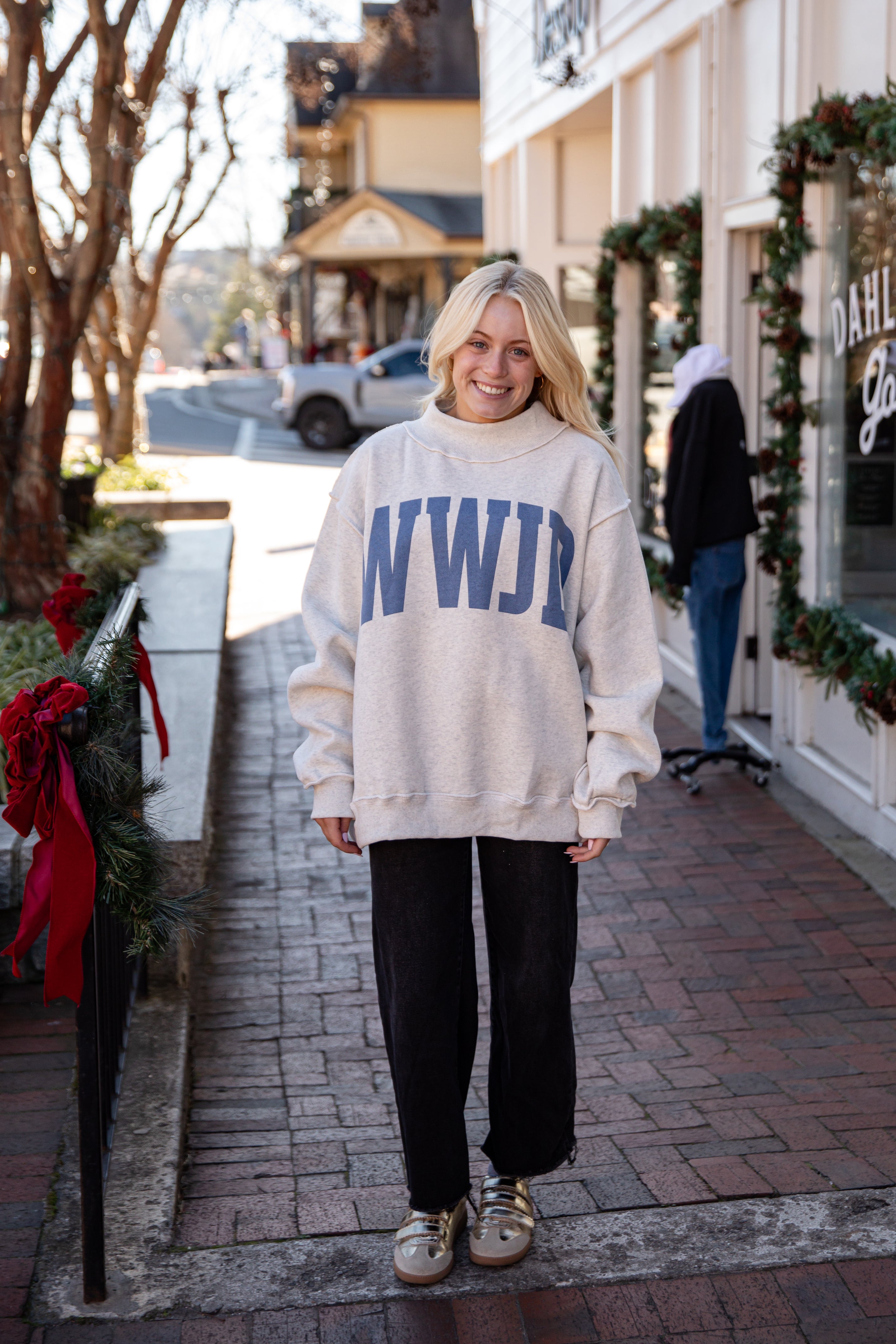 Person wearing a white sweatshirt with &
