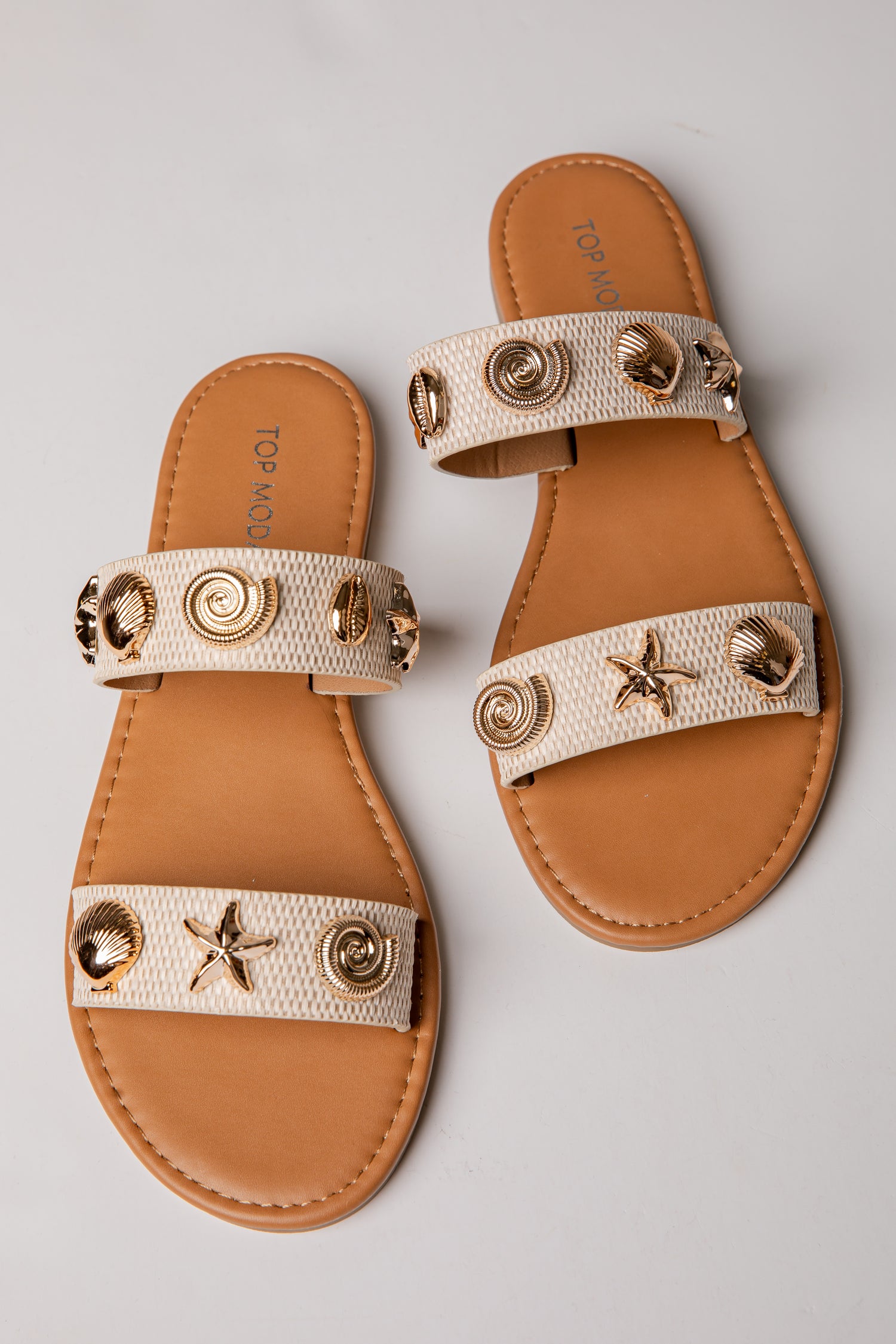 Pair of sandals with decorative straps on a gray background