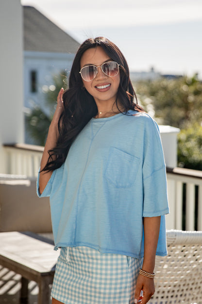 woman wearing a blue casual basic top with front pocket