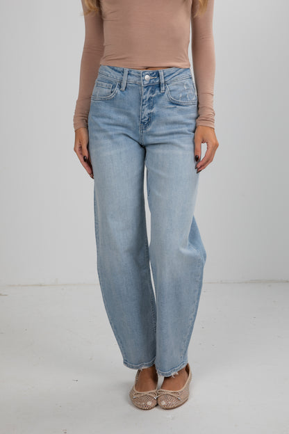 Person wearing light blue jeans and a beige top on a white background