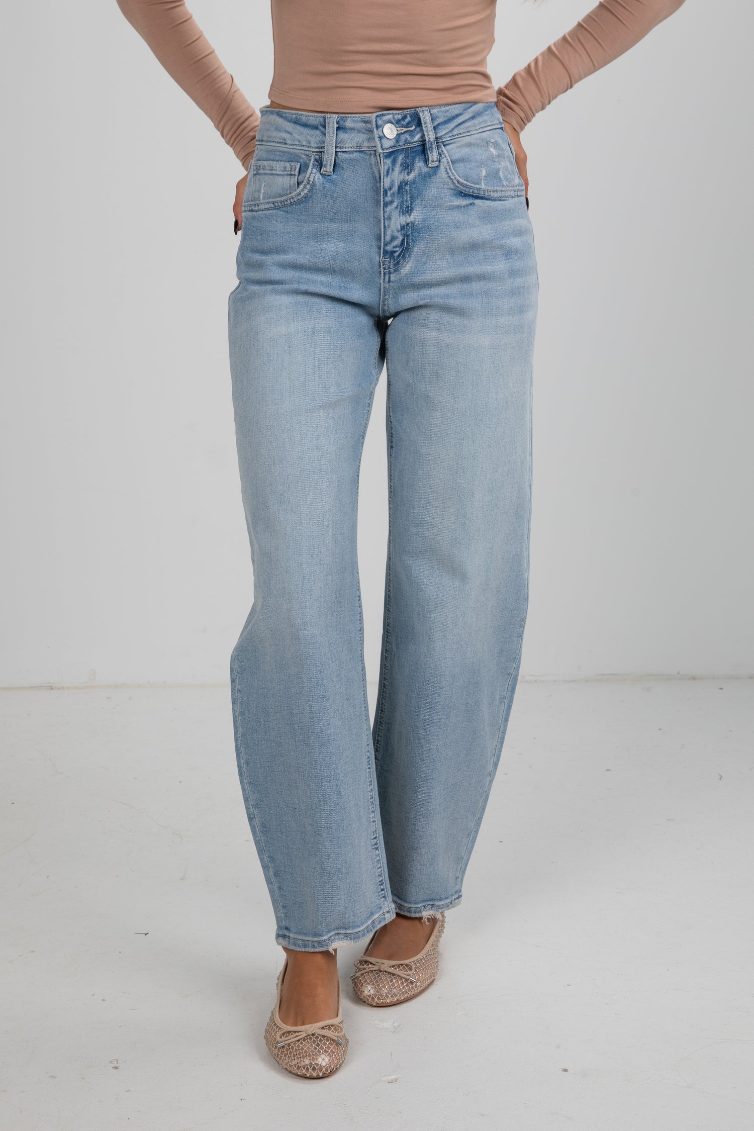 Person wearing light blue jeans on a white background