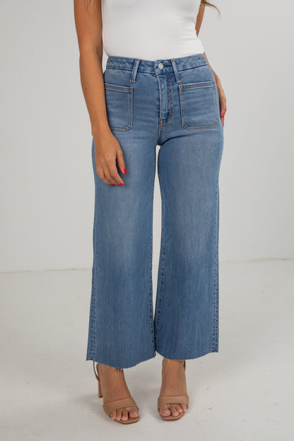 Person wearing blue wide-leg jeans on a plain background