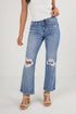Person wearing distressed blue jeans on a white background