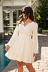 Woman in a white dress standing by a pool