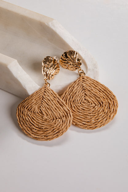 Pair of gold textured earrings on a light background