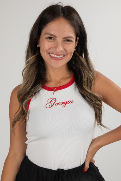 Woman wearing a white tank top with red trim and &