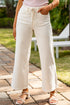 Person wearing white wide-leg pants and a light pink top outdoors on a patio.