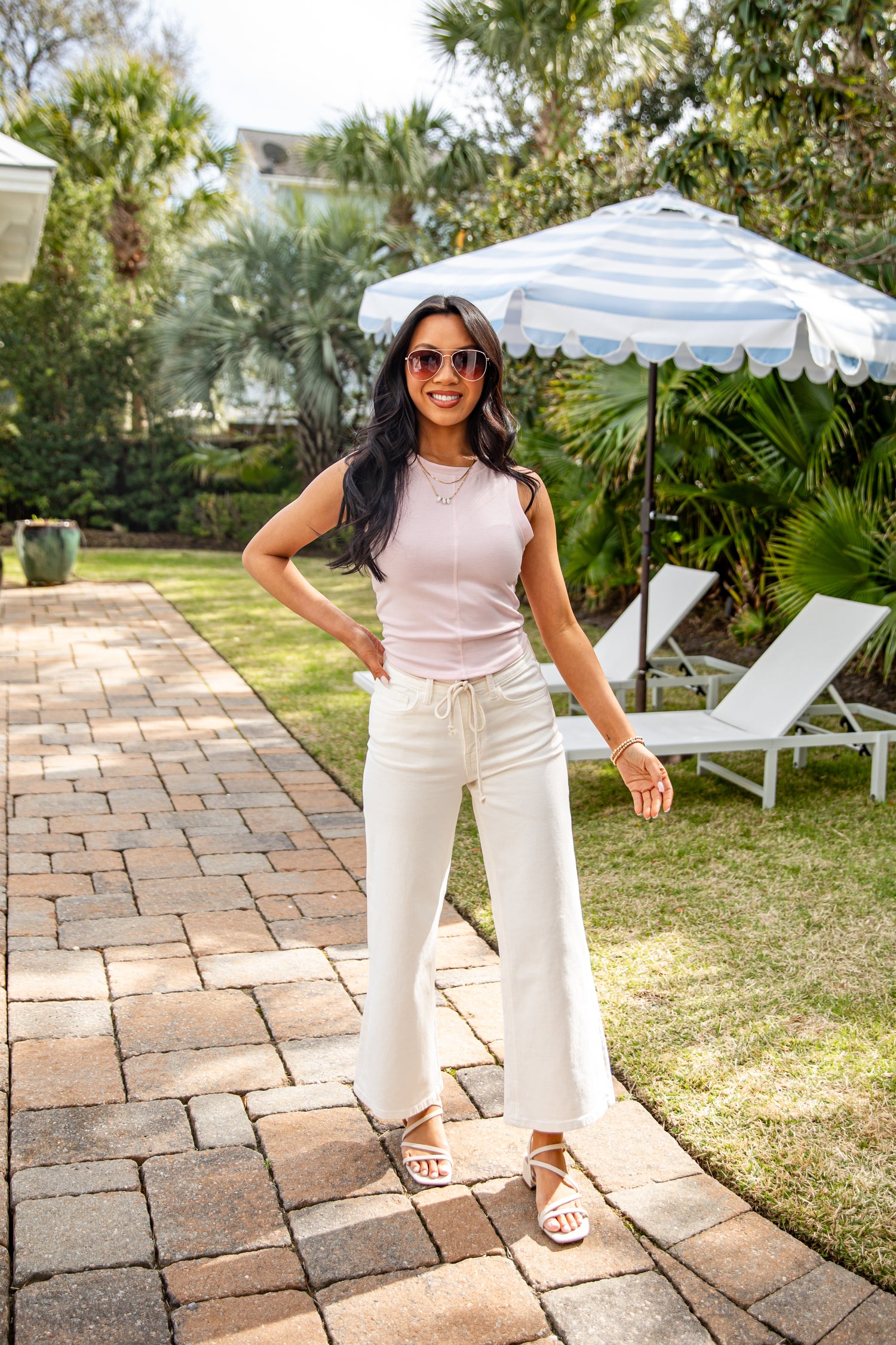 Woman standing on a patio with a garden background